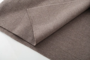 Detailed close-up of dark brown knit fabric showing fine needle stitching and soft texture