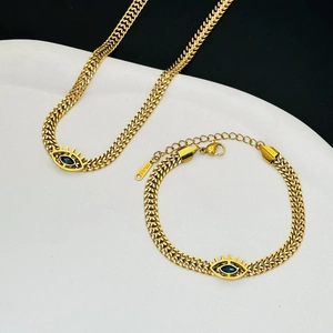 Detail of gold evil eye necklace and bracelet with blue oval stone and wheat chain