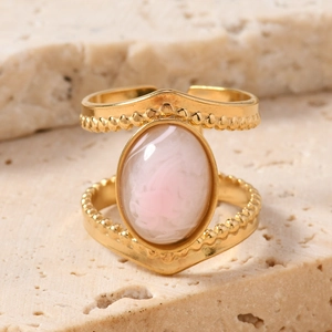 Macro shot of double-layered gold ring with a vintage oval natural pink stone inlay
