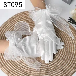 Detailed view of white bridal satin gloves featuring a sheer mesh bow and pearl accents