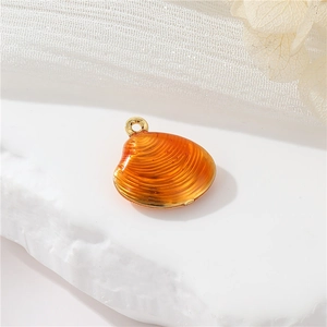Makroaufnahme Bernstein-Muschel-Anhänger mit Goldring auf weißem Stein und Stoff