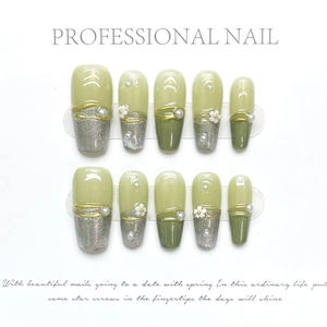 Macro view of olive green press-on nails featuring white 3D flowers and pearl details