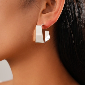 Close-up of geometric square hoop earring in polished silver metal on model's ear