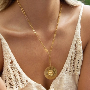 Detail of 18K gold stainless steel camellia pendant necklace on paperclip chain