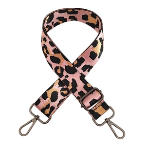 Close-up of pink leopard jacquard bag strap with dark gunmetal buckles and adjusters