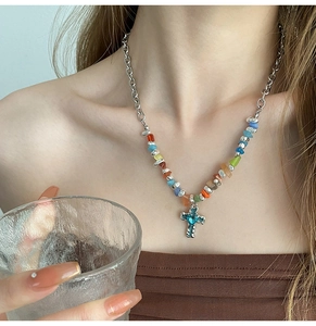 Detail of bohemian cross necklace with blue heart rhinestone and colorful stone beads
