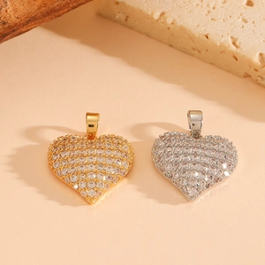 Detail of gold and silver heart pendants with sparkling cubic zirconia on stone base