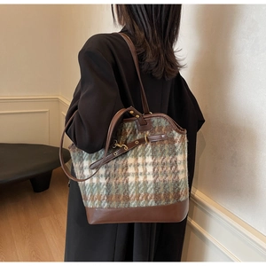 Detail of vintage coffee plaid tote bag showing contrast leather trim and dual straps