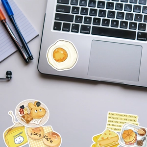 Detailansicht süßer Frühstücksaufkleber auf Laptop mit Ei- und Brotmotiven