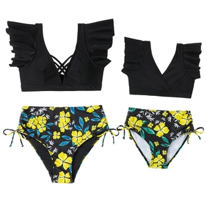 Matching mother daughter two-piece swimsuits with black ruffled tops and floral high-waist bottoms