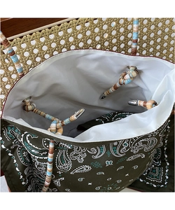 Detail view of paisley canvas tote bag with white lining and knotted woven rope strap