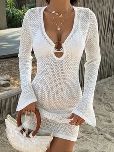 Close-up of white knit beach dress featuring a deep V-neck and ring detail on the front