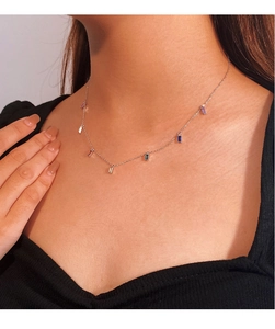 Detail of multi-colored rectangular zircon pendant necklace on a model neck