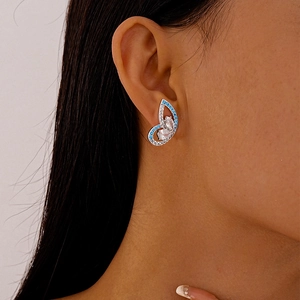 Elegant butterfly earrings with blue and white zircons worn on ear for women