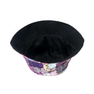 Flat lay of bucket hat showing purple cat print and contrast black lining detail