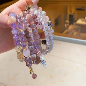 Close-up of natural amethyst and citrine beaded bracelets with elegant metal charms