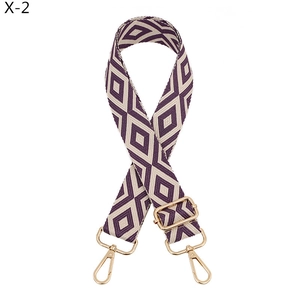 Detail view of purple and beige diamond pattern jacquard strap with gold metal hooks