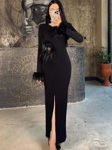 Eng anliegendes schwarzes Langarmkleid mit Federn an den Manschetten und Frontschlitz