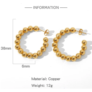 Vue détaillée de boucles d'oreilles créoles dorées de 38 mm de diamètre sur fond blanc pur