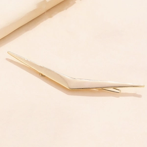 Minimalist gold alloy V-shaped geometric hair clip with a polished finish on a soft background