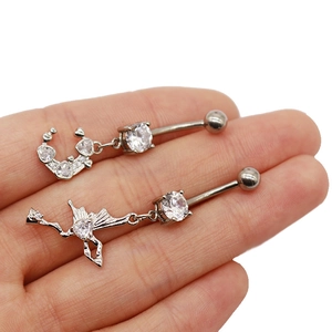 Détail de piercings de nombril cœur argentés avec croissant de lune et fée en cristaux