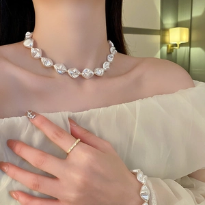 Vue détaillée de l'ensemble collier et bracelet en perles baroques et fermoir en T doré