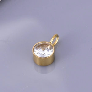 Detailed macro view of a gold-plated circular crystal pendant with faceted clear gemstone