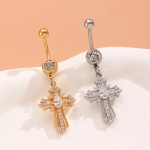 Macro shot of silver and gold heart cross belly rings with zircon on a wavy stand