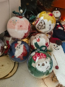 Close-up of festive Christmas coral fleece socks in decorative clear ornament gift balls