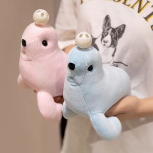 Soft plush seal doll set in pink and blue held by hands for size reference