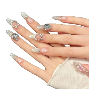 Unghie finte artigianali sfumate color pesca con glitter argentati e fiocchi di neve