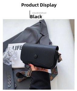 Detailed view of black litchi grain leather crossbody bag with bohemian wide strap