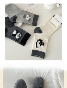 Detailed view of flocked cartoon animal patterns on soft combed cotton mid-calf socks