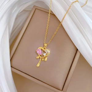 Gold necklace with melting heart pendant featuring a pink drop stone and crystals