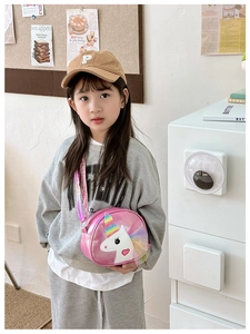 Pink unicorn crossbody bag styled with a brown baseball cap and grey casual outfit