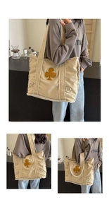 Detailed close-up of beige canvas tote bag featuring brown club pattern and frayed edges