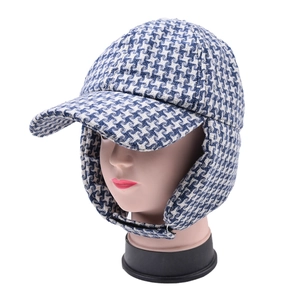 Close-up of blue houndstooth winter trapper hat with ear flaps and warm lining