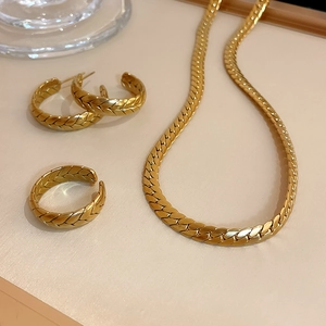 Detailed view of 3-piece gold stainless steel jewelry set with woven texture finish