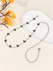 Detail view of silver butterfly waist chain with black accents and rose pendant decor