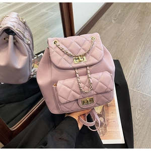 Detail of pink quilted leather backpack featuring gold turn-lock and chain straps
