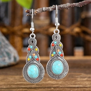 Detail view of vintage bohemian drop earrings with turquoise stones on a branch