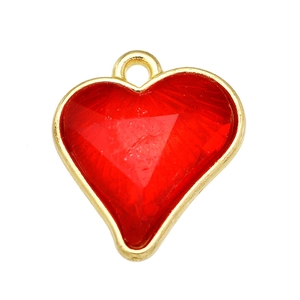 Macro shot of a red crystal heart pendant with a gold metal frame and top ring loop