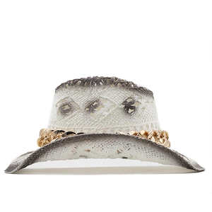 Detail of white hollow woven straw hat featuring gradient grey edges and golden metal chain