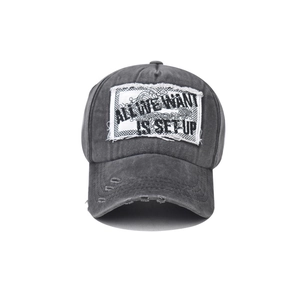 Détail d'une casquette de baseball en coton gris délavé avec écusson et bord effiloché