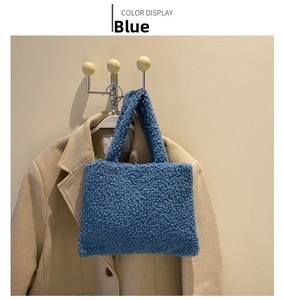 Close-up of blue fuzzy plush tote bag hanging on a beige winter coat showing soft texture