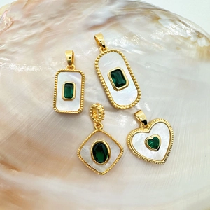 Detail of 18K gold plated shell pendants with emerald green gemstone inlays