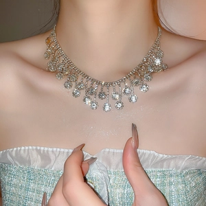 Close-up of diamond zircon flower tassel necklace on model with luxury silver finish