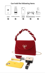 Detail of red velvet handbag with pearl handle and golden bow clasp showing spacious interior