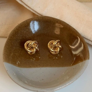 Minimalist twisted metal knot stud earrings in 18K gold finish for a retro aesthetic