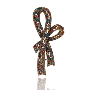 Spilla a fiocco vintage di lusso in bronzo con strass colorati su sfondo bianco puro